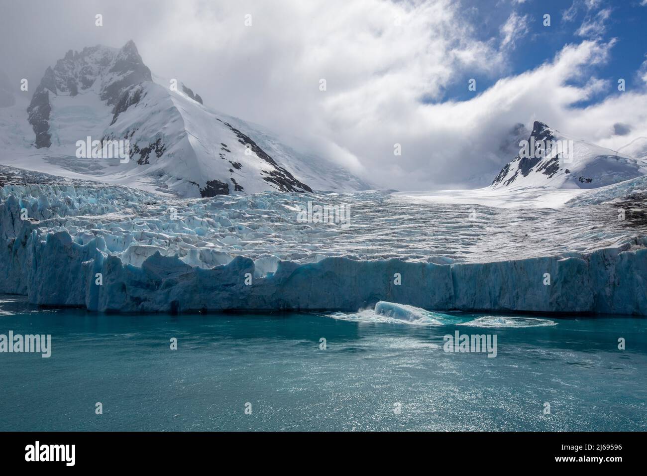 A view of snow-capped mountains and a shooter from the glacier in Drygalski Fjord, South Georgia, South Atlantic, Polar Regions Stock Photo