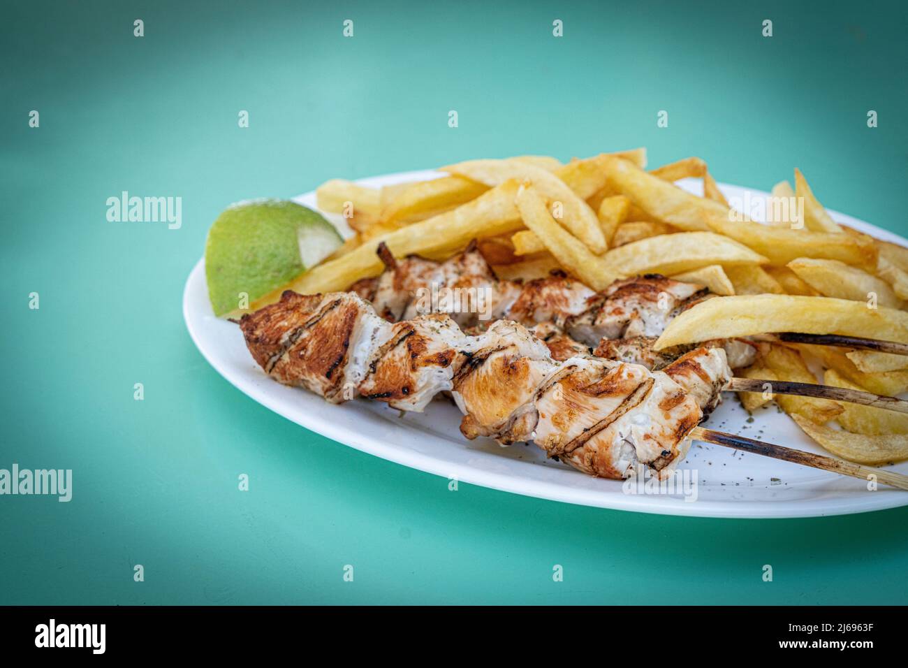 Souvlaki, popular Greek food consisting of small pieces of meat grilled on a skewer served with french fries, Greek Islands, Greece, Europe Stock Photo