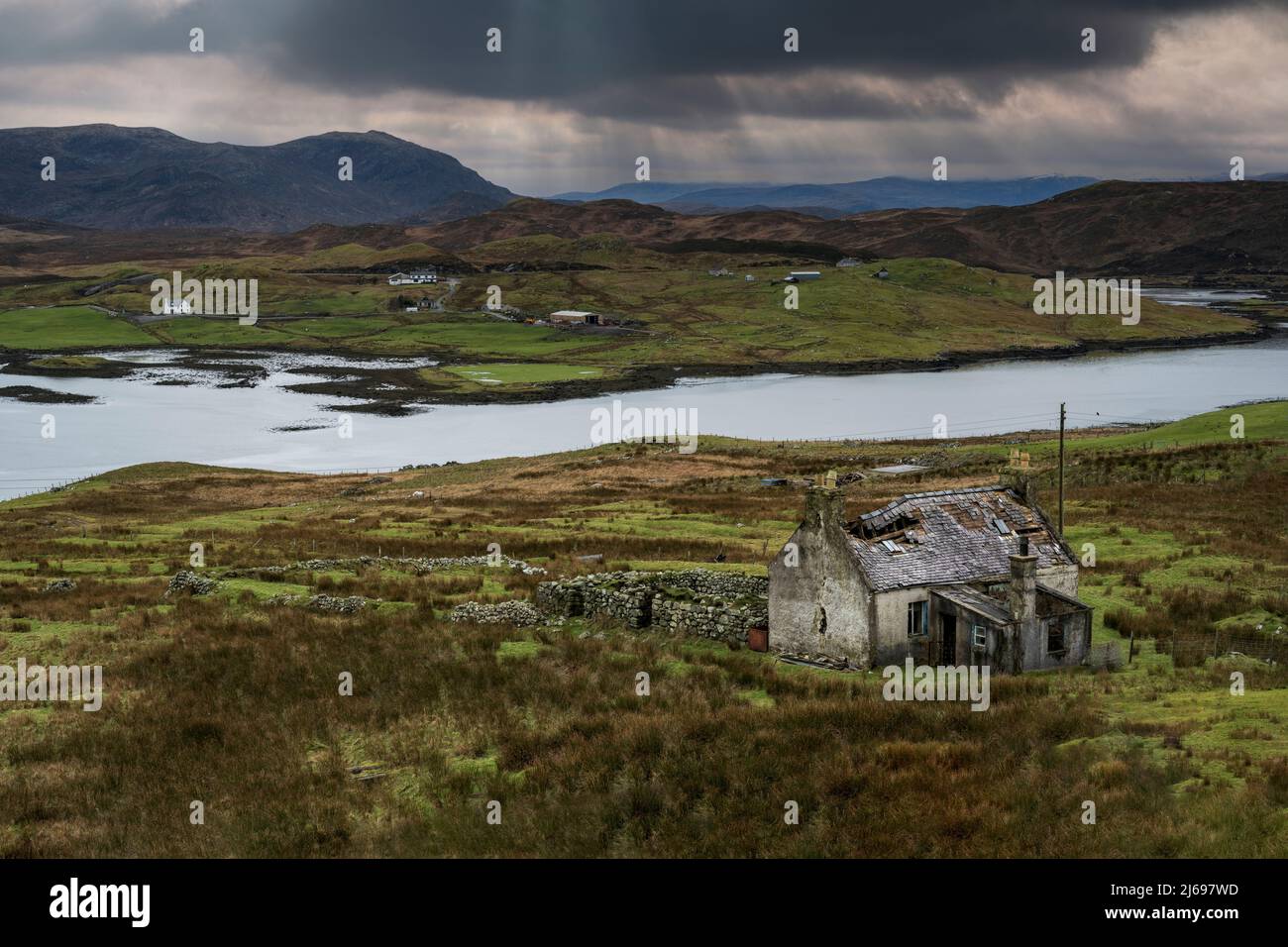 Abandoned croft backed by Loch Eireasort and the Harris Hills, near Baile Ailein, Isle of Lewis, Outer Hebrides, Scotland, United Kingdom, Europe Stock Photo