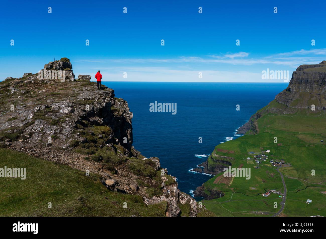 Hiker on The Postman's Trail to the village of Gasaldur, Vagar Island, Faroe Islands, Denmark Stock Photo