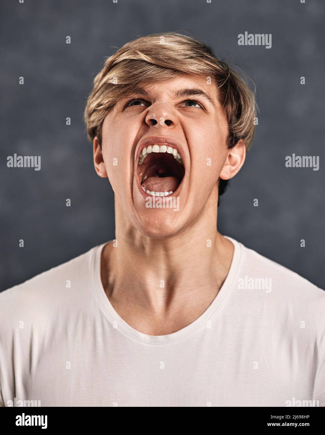 Furious, enraged young man over gray background Stock Photo