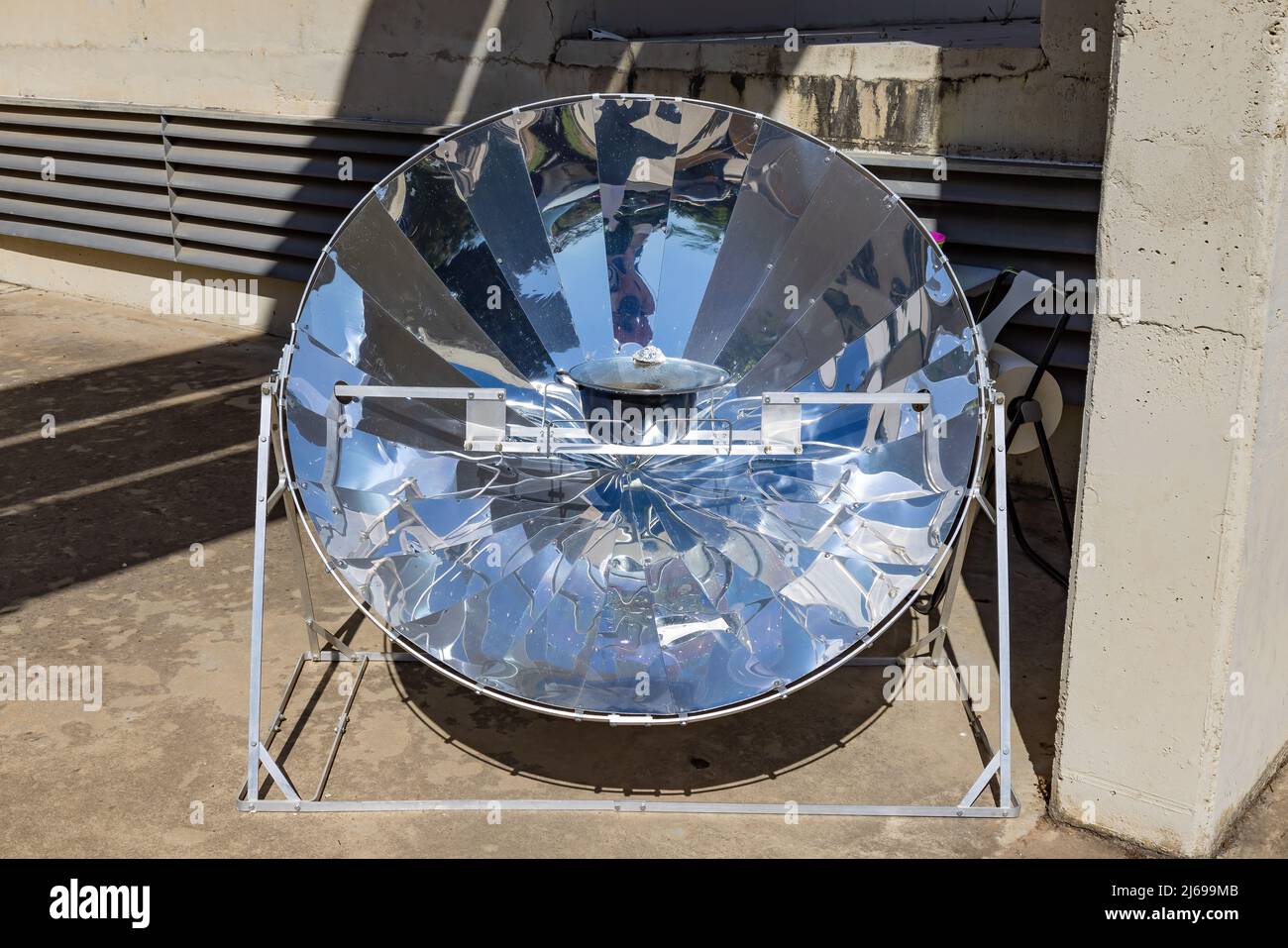 Cooking with sun energy, parabolic solar oven in the middle of cooking a dish thanks to solar energy Stock Photo