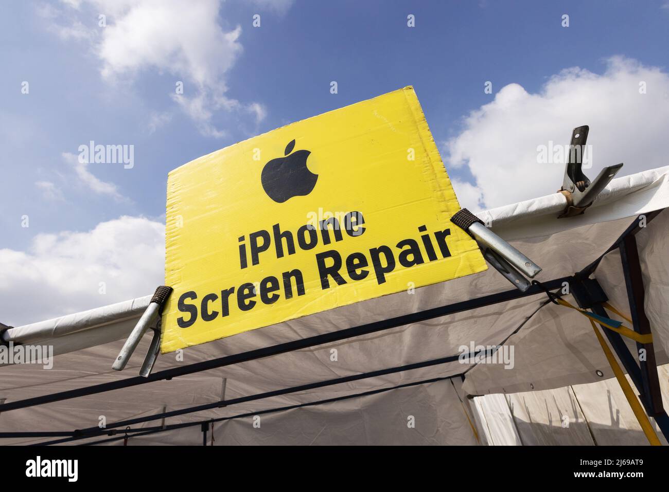 Apple iPhone screen repair sign at a mobile phone repair stall, Suffolk UK Stock Photo