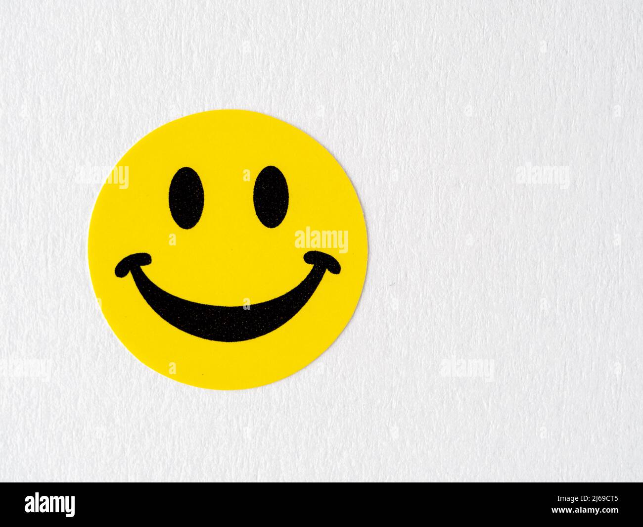 yellow arts and craft smilling happy face sticker on a white background Stock Photo