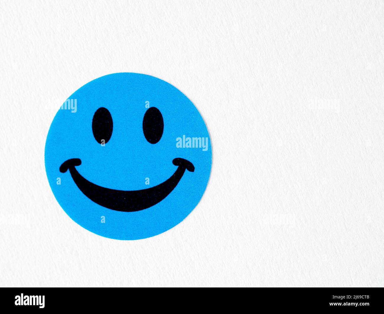 Blue  craft smilling happy face sticker on white background Stock Photo
