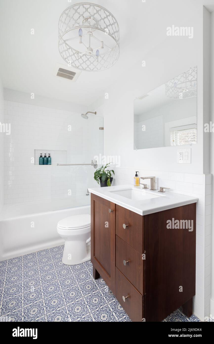 A renovated bathroom with a blue and white mosaic tile floor, wood ...
