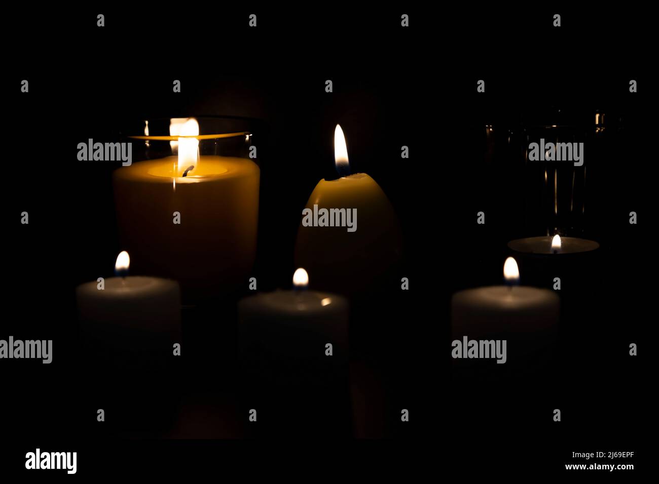 Photo of different candles burning at night with golden light, candle flame Stock Photo