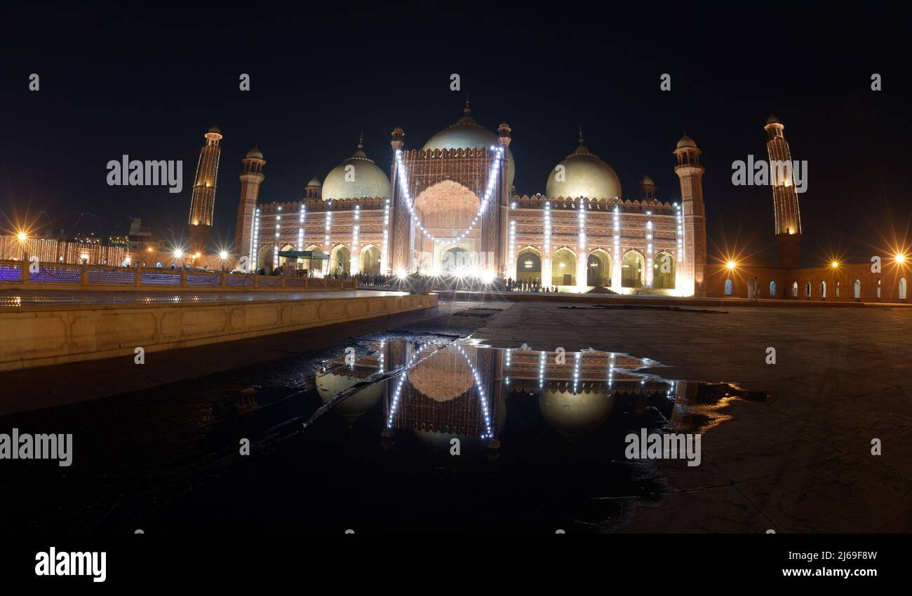 An attractive splendid stunning aerial view of historical Mughal Era Badshahi mosque decorated with lights to mark the holy night and seek divine blessings of Lailatul Qadr, also known as the Night of Power in Lahore. Laylat ul Qadr or commonly known as Shab-e-Qadr, the ‘Night of Power’ is full of blessings because the eminent Quran descended in it, Muslim worshipers arrive to offer evening prayers 27th night of the Holy month of Ramadan at an illuminated Badshahi Mosque' according to tradition, when the Muslim holy book, the Koran, was revealed to the Prophet Mohammed through the angel Gabrie Stock Photo