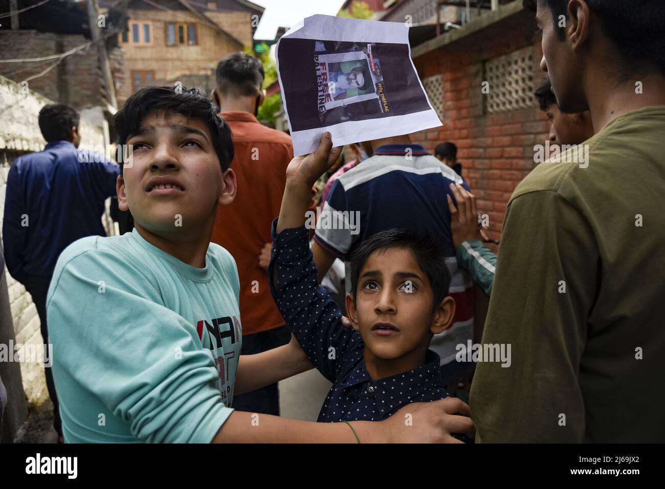 A Kashmiri boy holds a placard as they look on, during a rally marking ...
