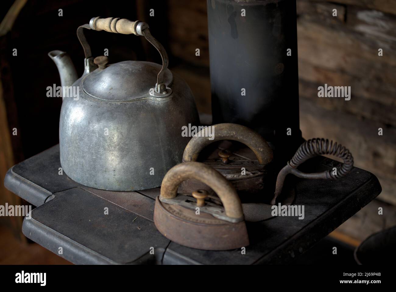 Vintage teakettle and ironon an 18th century stove. . Stock Photo
