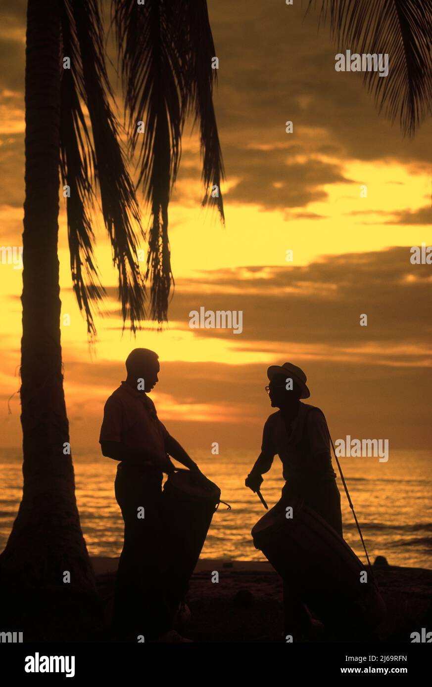 Two men in silhouette playing drums on the beach, Maracaibo Lake, Zulia State, Venezuela Stock Photo