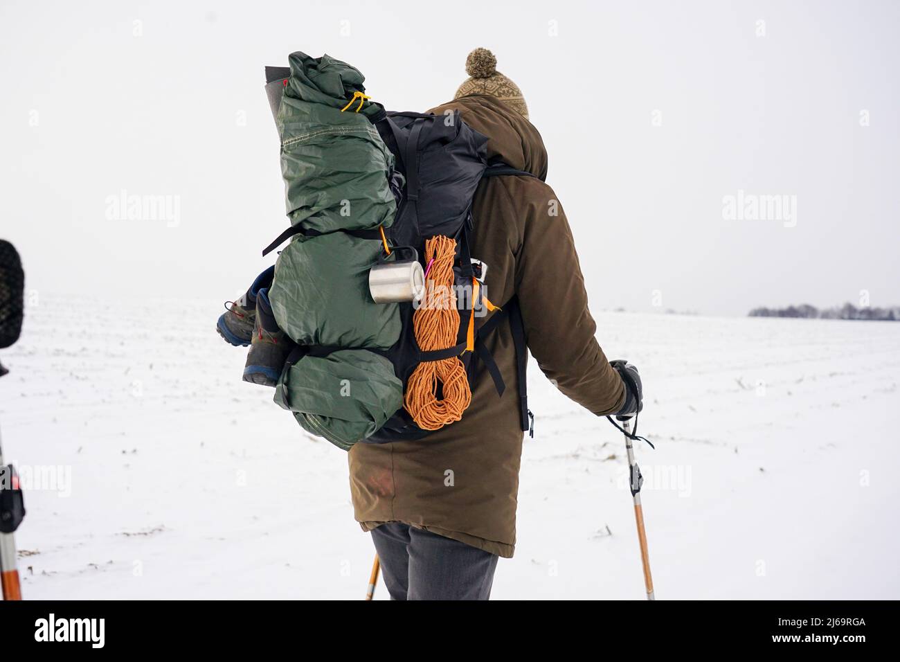 men in  winter gear are walking through the snow. Winter expedition to the checked pole. A man carries a large backpack Stock Photo
