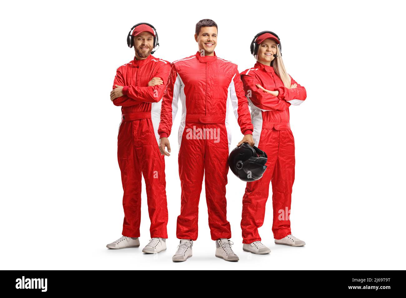 Racer and members of a racing team in red overall suits posing and looking at camera isolated on white background Stock Photo