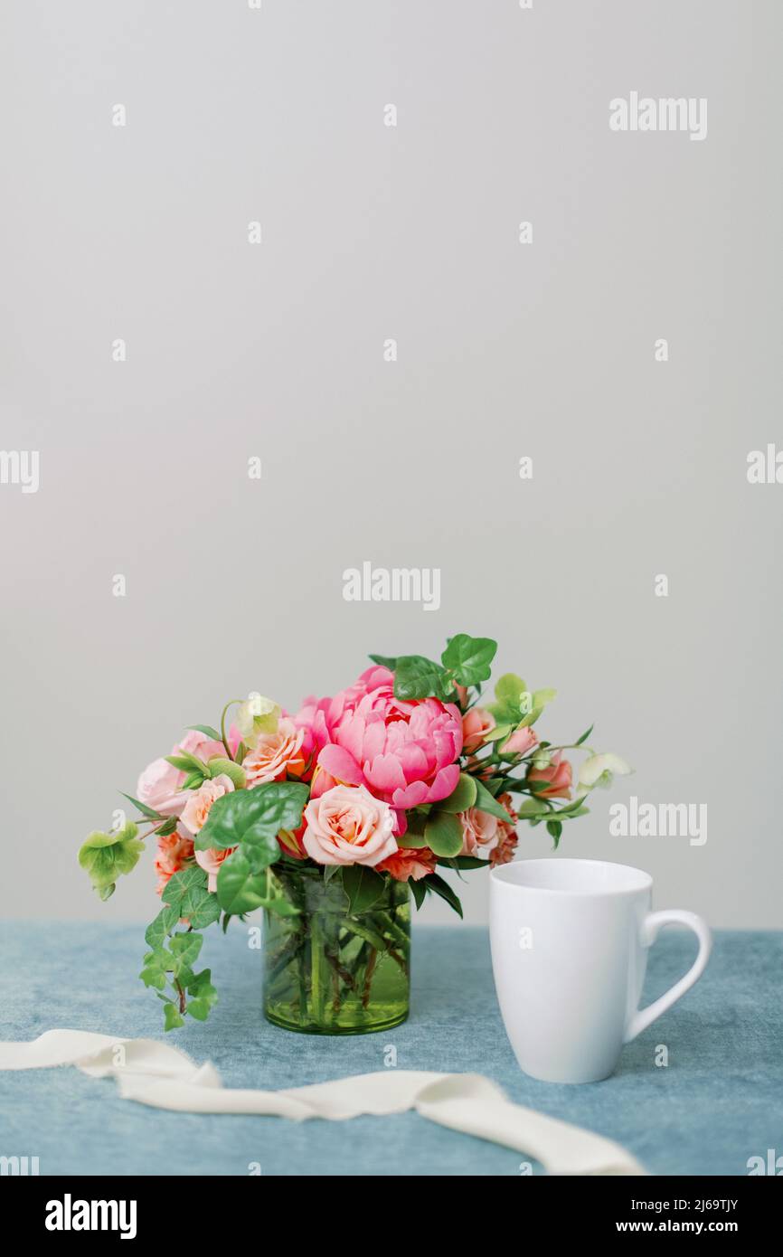 pink and peach flower centerpiece with white coffee mug Stock Photo Alamy