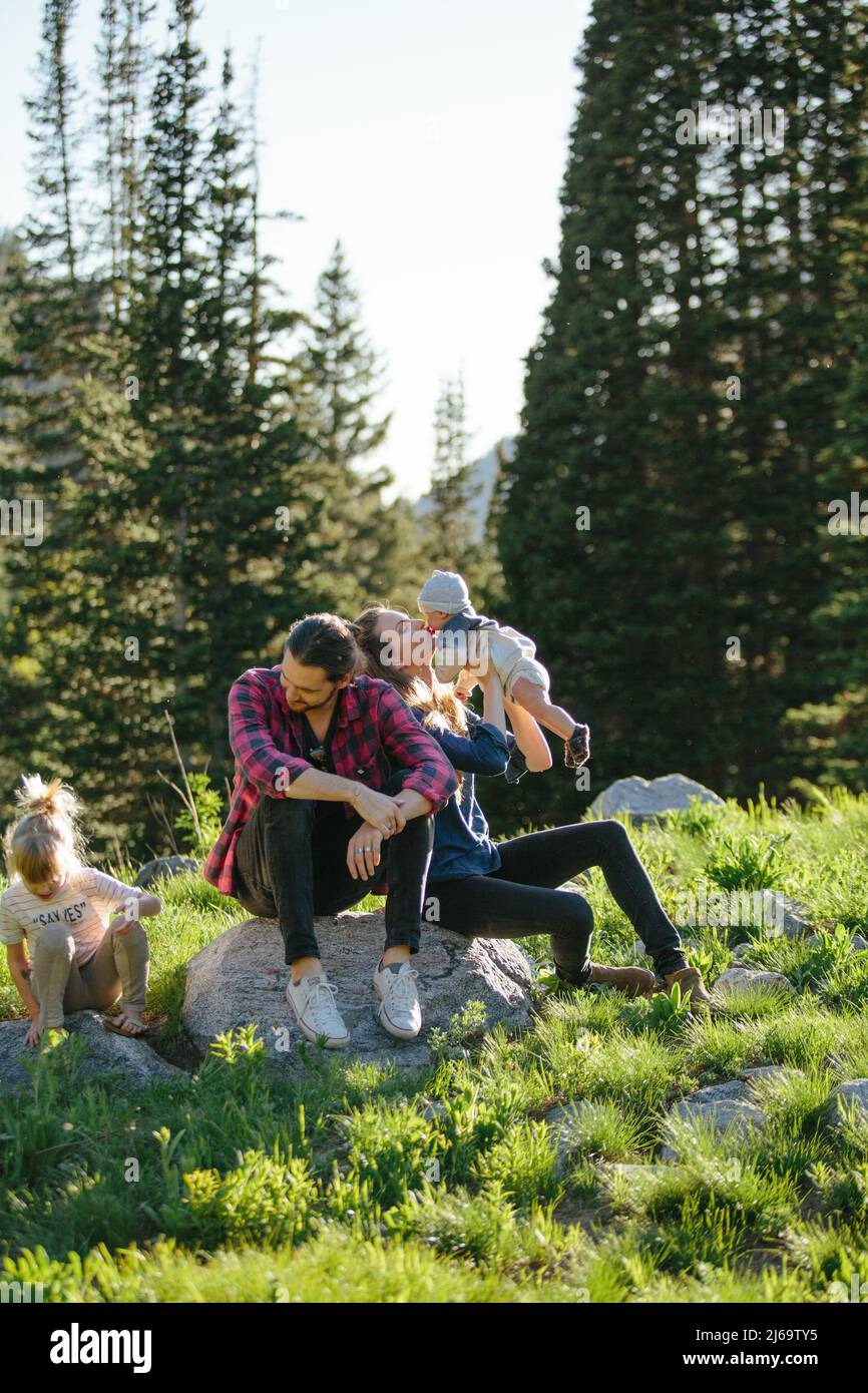 Candid family exploring nature together and kissing baby Stock Photo