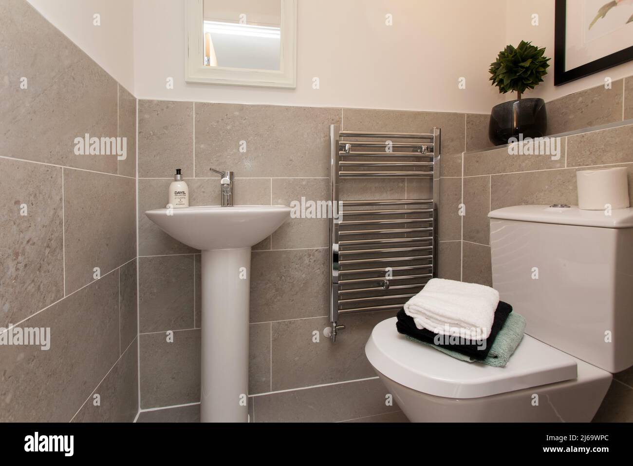 Toilet and washbasin, downstairs loo, modern new build house, tiled in neutral colours Stock Photo