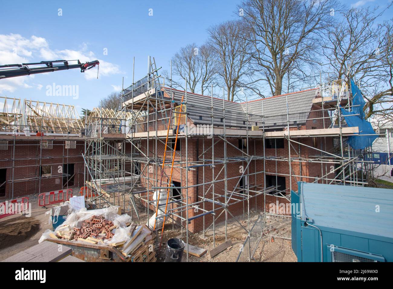 Work in progress, building site,building work,scaffolding,ladders,roofing,brickwork,bricks, skip with rubbish. Stock Photo
