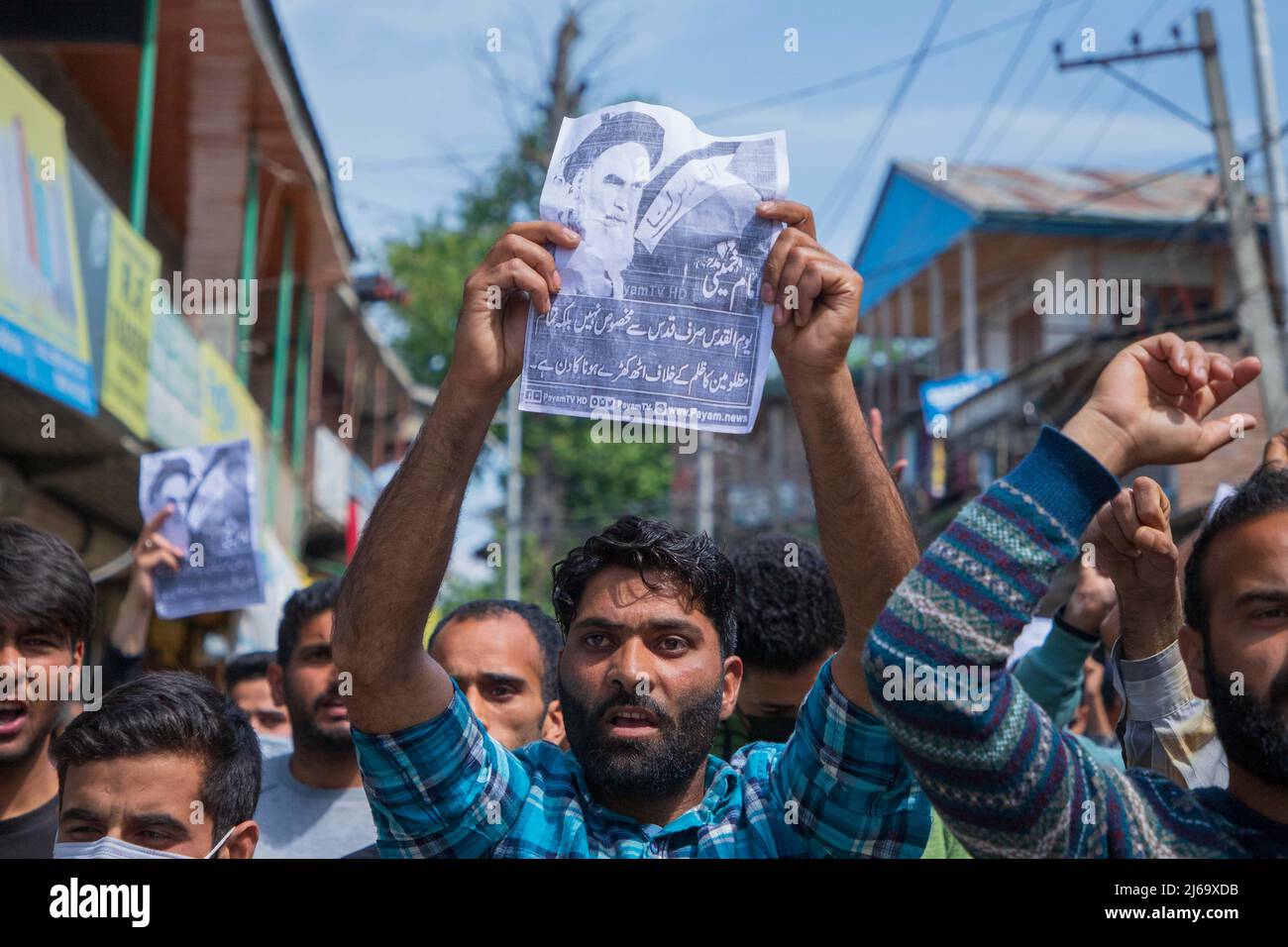 A Kashmiri Shiite Muslim holds a placard while shouting pro Palestine ...