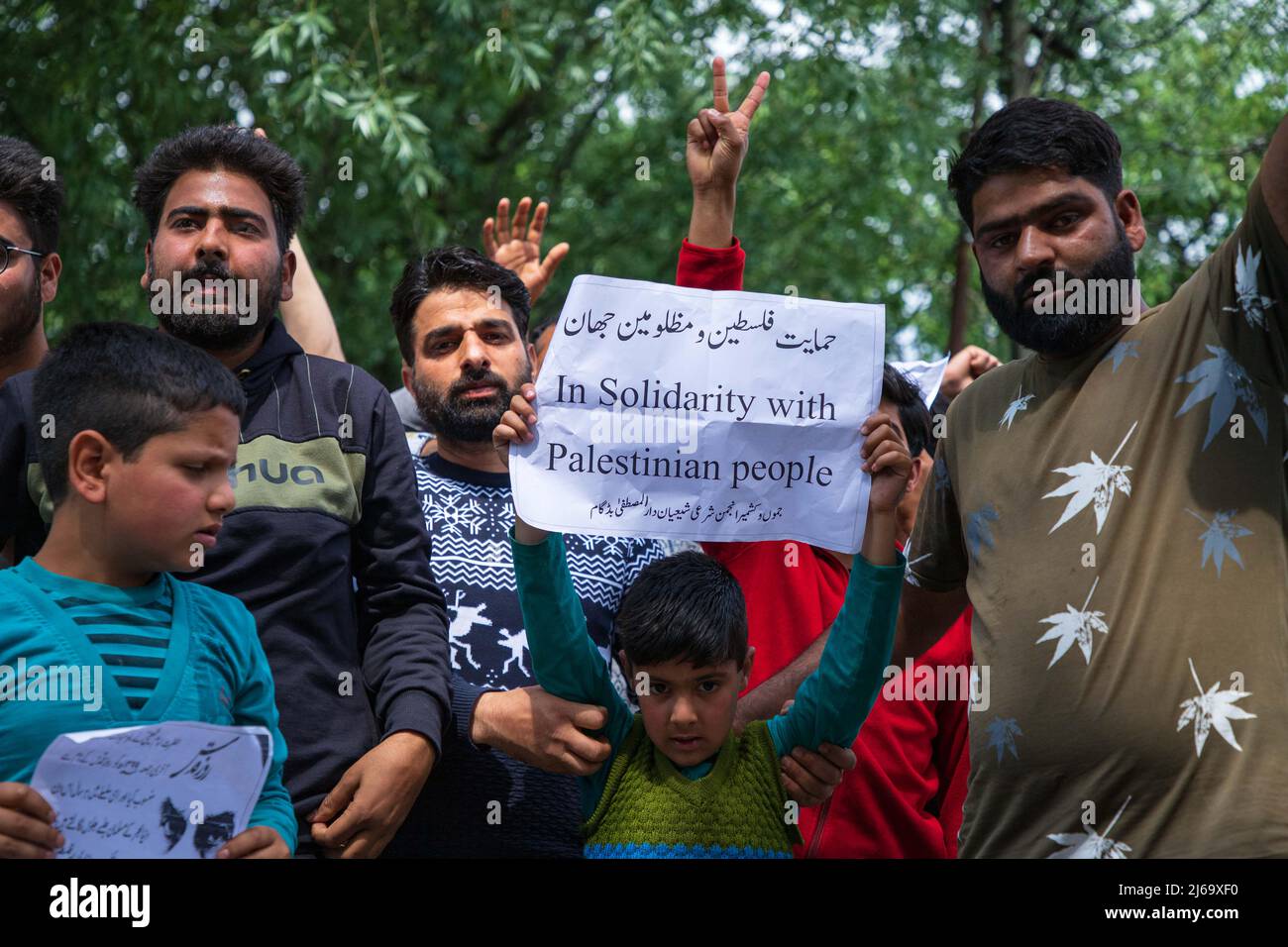 A Kashmiri Shiite Muslim holds a placard while shouting Pro Palestine ...