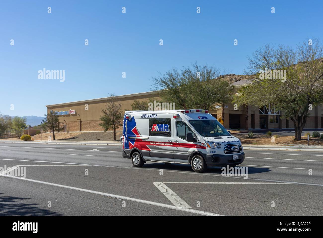 Apple Valley, CA, USA – April 20, 2022: AMR ambulance van traveling on Happy Trails Highway in the Town of Apple Valley, California. Stock Photo