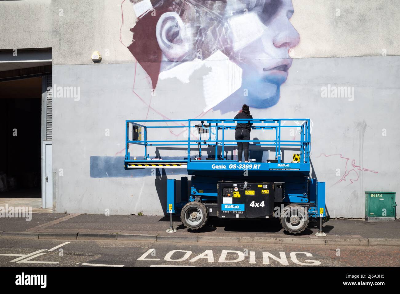 Street artist painting a mural in the Co. Antrim town of Larne, Northern Ireland Stock Photo