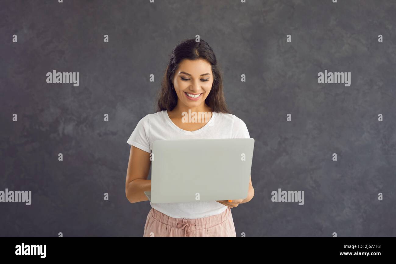 Smiling woman use laptop work online on device Stock Photo