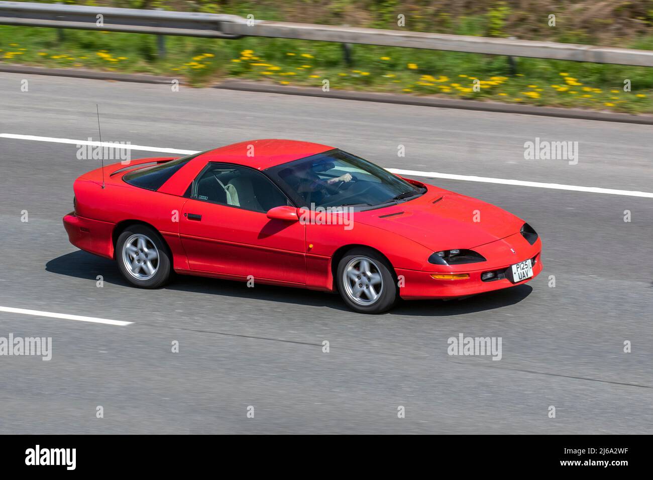 1997 90s nineties red Chevrolet GMC Camaro 3800cc American left-hand drive petrol coupe; driving on the M61 motorway in Manchester, UK Stock Photo