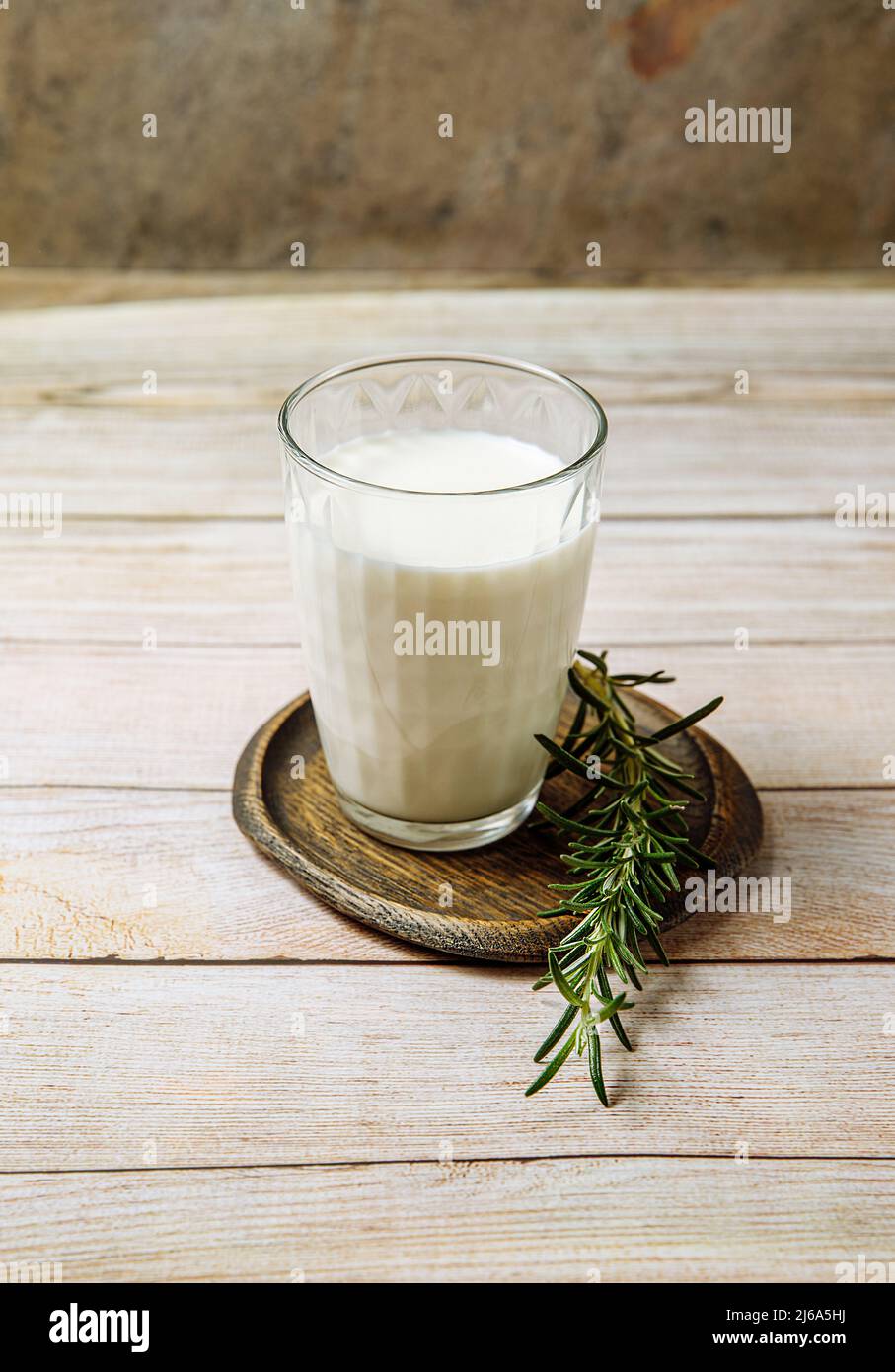 Large glass of milk and rosemary on an old wooden table, dairy products, stock photo. Stock Photo