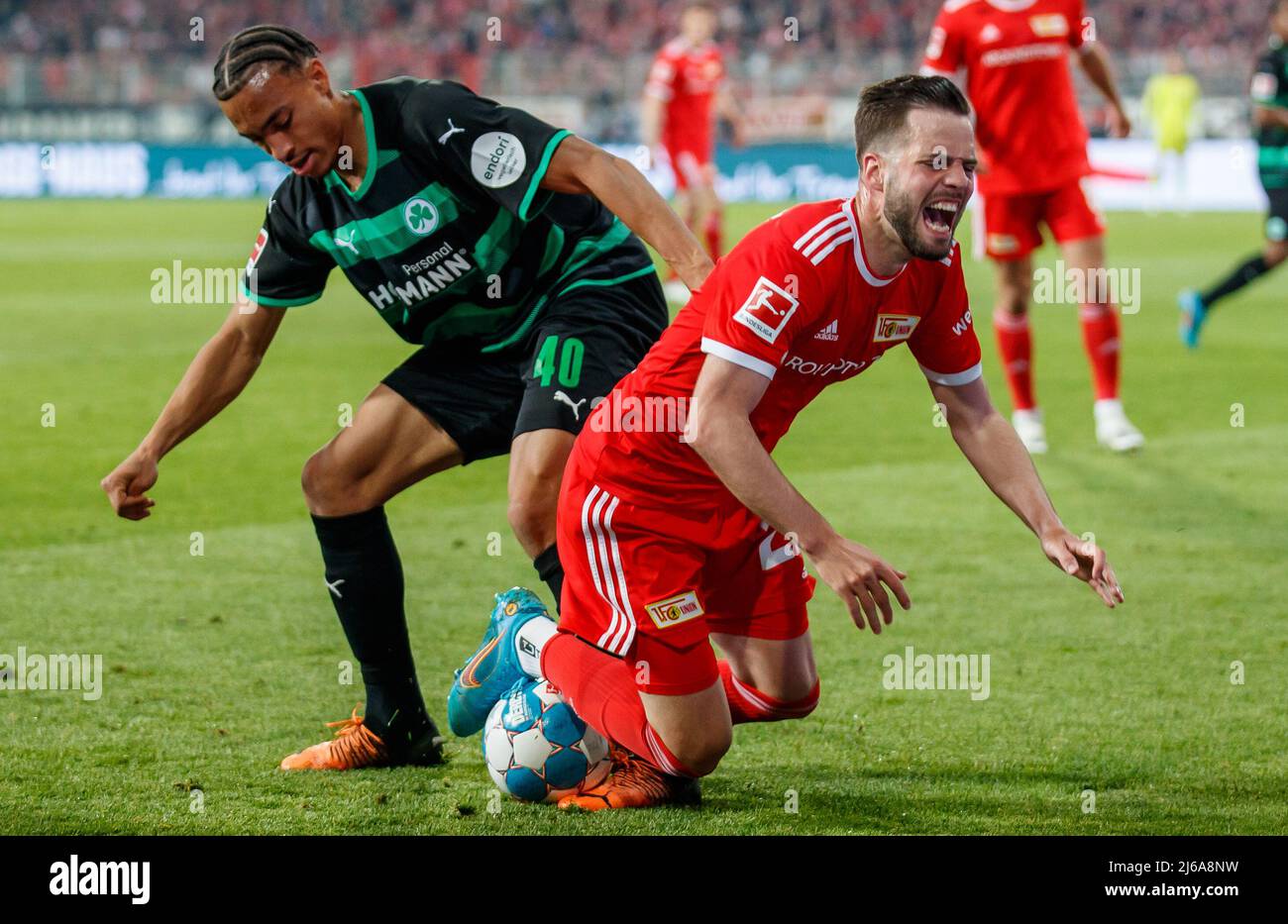 Germany. 29th Apr, 2022. 29 April 2022, Berlin: Soccer: Bundesliga, 1. FC Union Berlin - SpVgg Greuther Fürth, Matchday 32, An der Alten Försterei. Berlin's Niko Gießelmann (r) goes down after a foul by Greuther Fürth's Jamie Leweling. Photo: Andreas Gora/dpa - IMPORTANT NOTE: In accordance with the requirements of the DFL Deutsche Fußball Liga and the DFB Deutscher Fußball-Bund, it is prohibited to use or have used photographs taken in the stadium and/or of the match in the form of sequence pictures and/or video-like photo series. Credit: dpa picture alliance/Alamy Live News Stock Photo