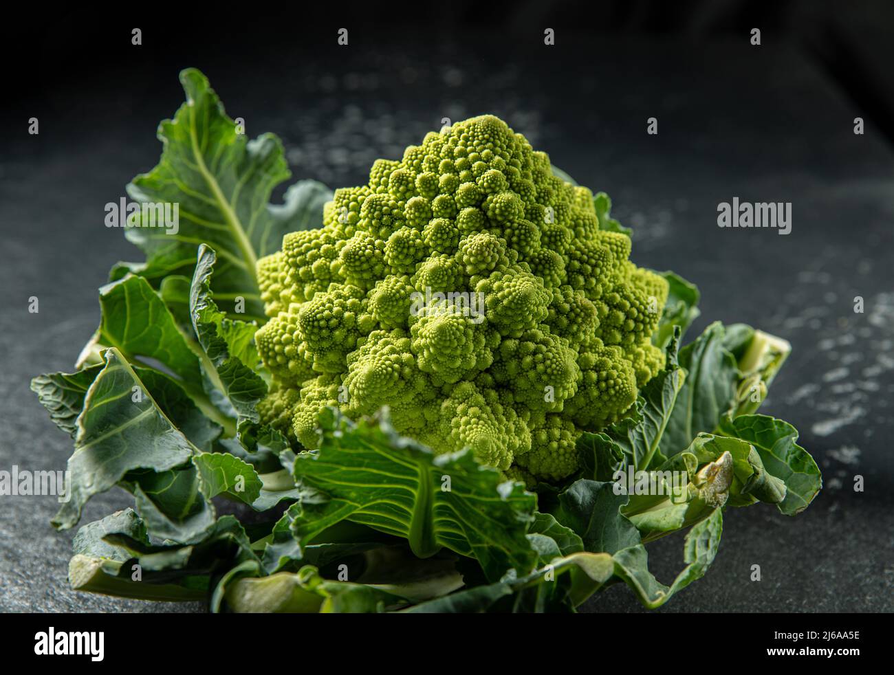 Romanesco broccoli head on a dark stone surface, cabbage, close up, fibonacci sequence, for those who love mathematics, stock photo Stock Photo