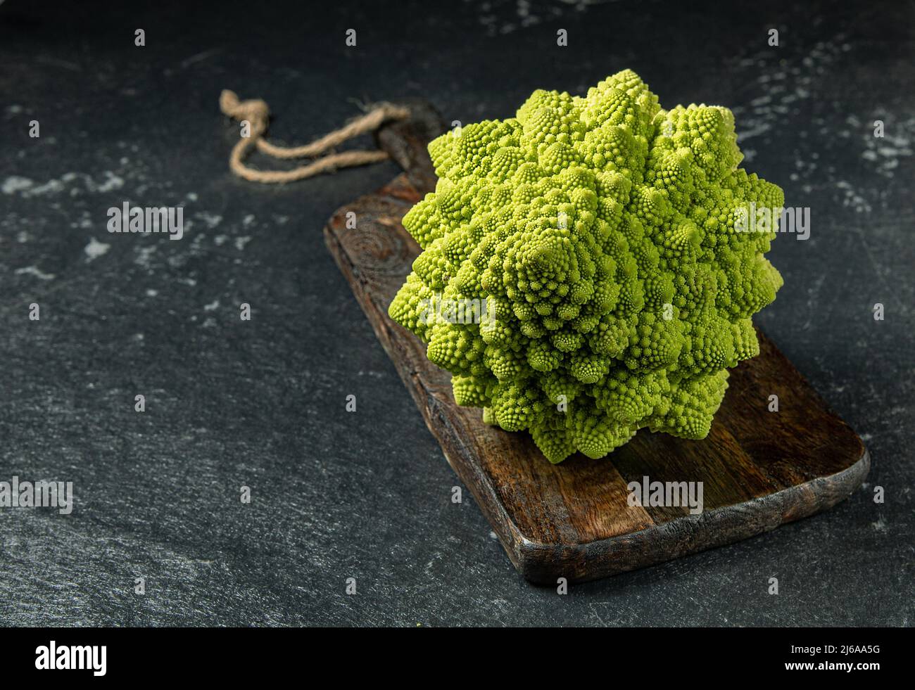Romanesco broccoli head on a dark stone surface, cabbage, close up, fibonacci sequence, for those who love mathematics, stock photo Stock Photo