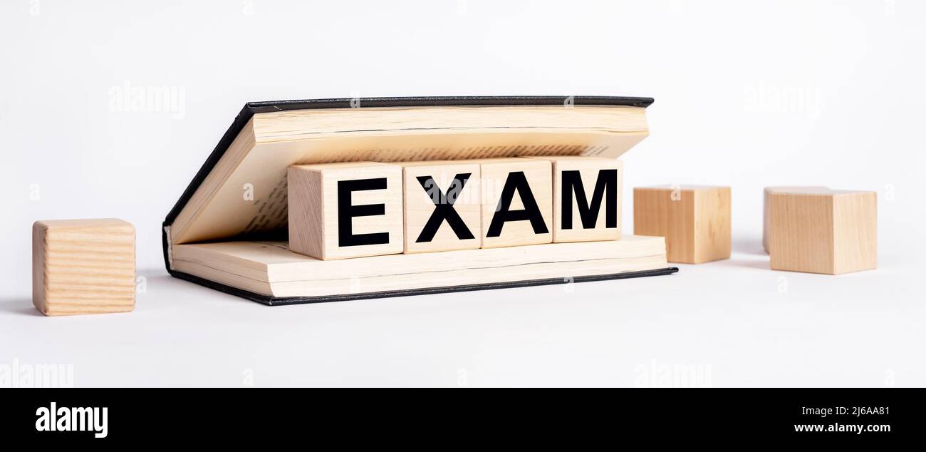 Book with wooden blocks with word exam. Preparation for examination, education concept. Information study and revision. High quality photo Stock Photo
