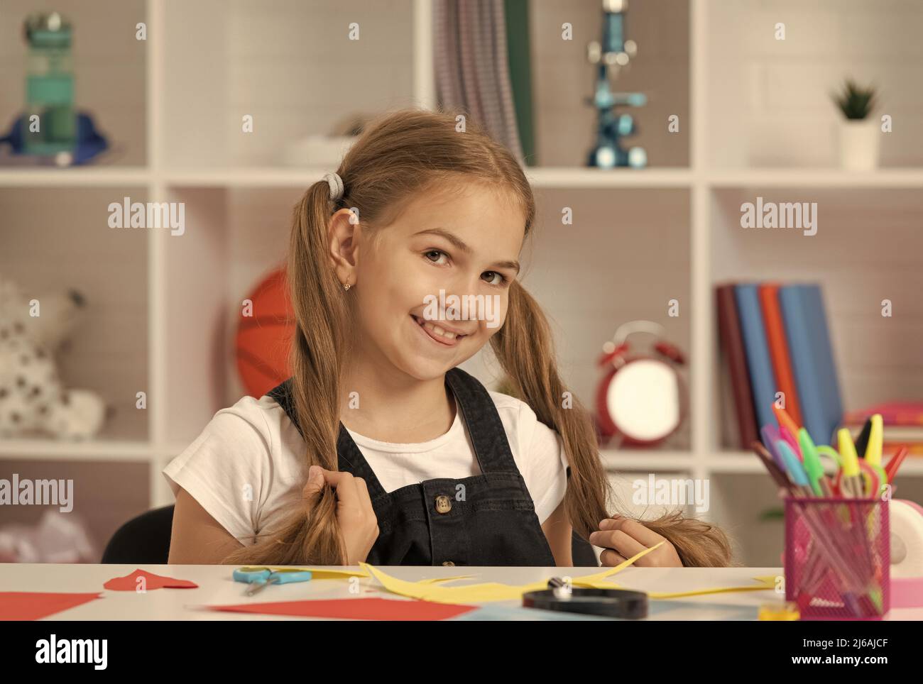 happy pretty child having fun with long hair pony tail at school lesson ...