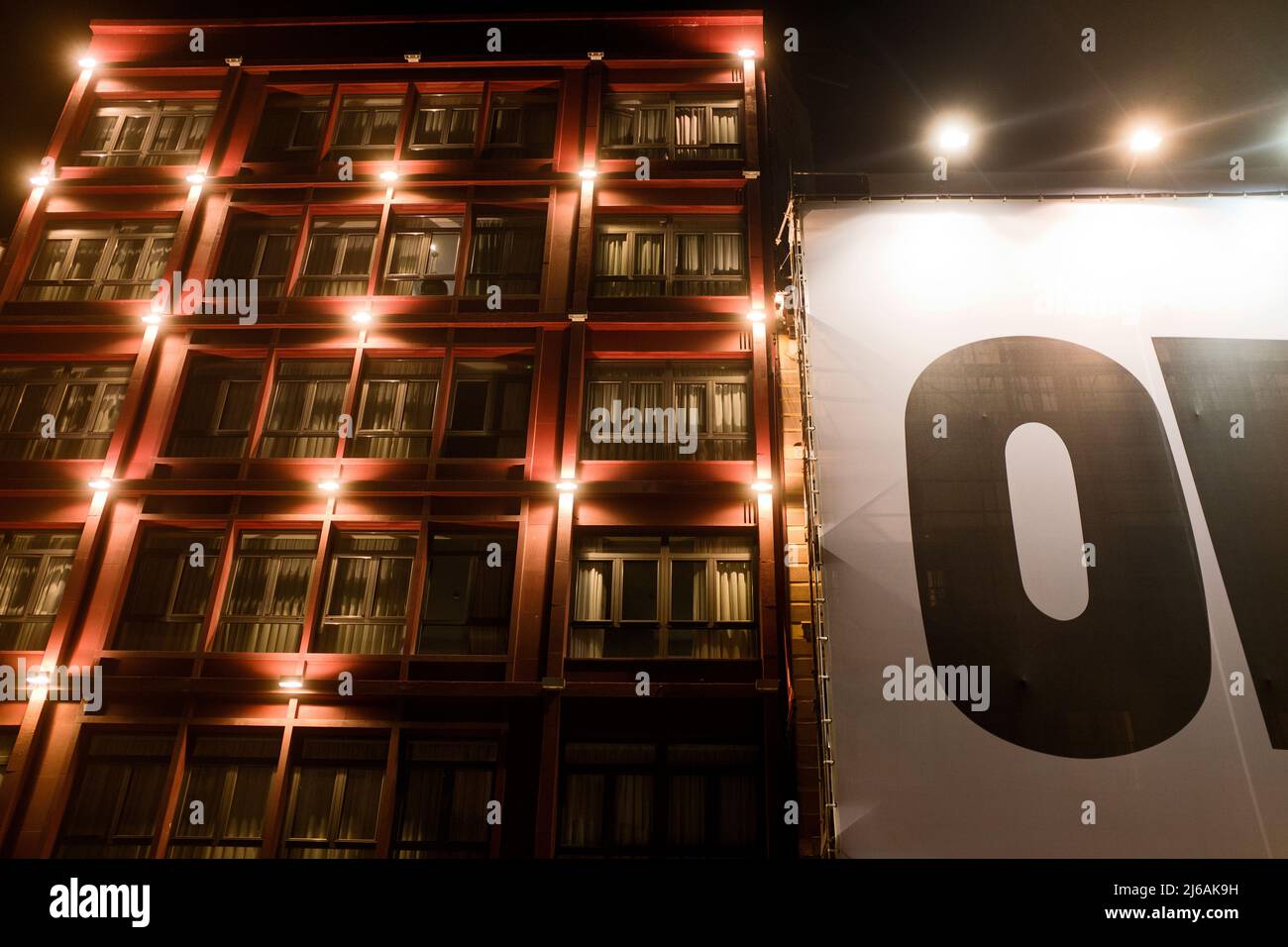 Illuminated Apartment Building with large canvas sign at Night, Madrid, Spain Stock Photo