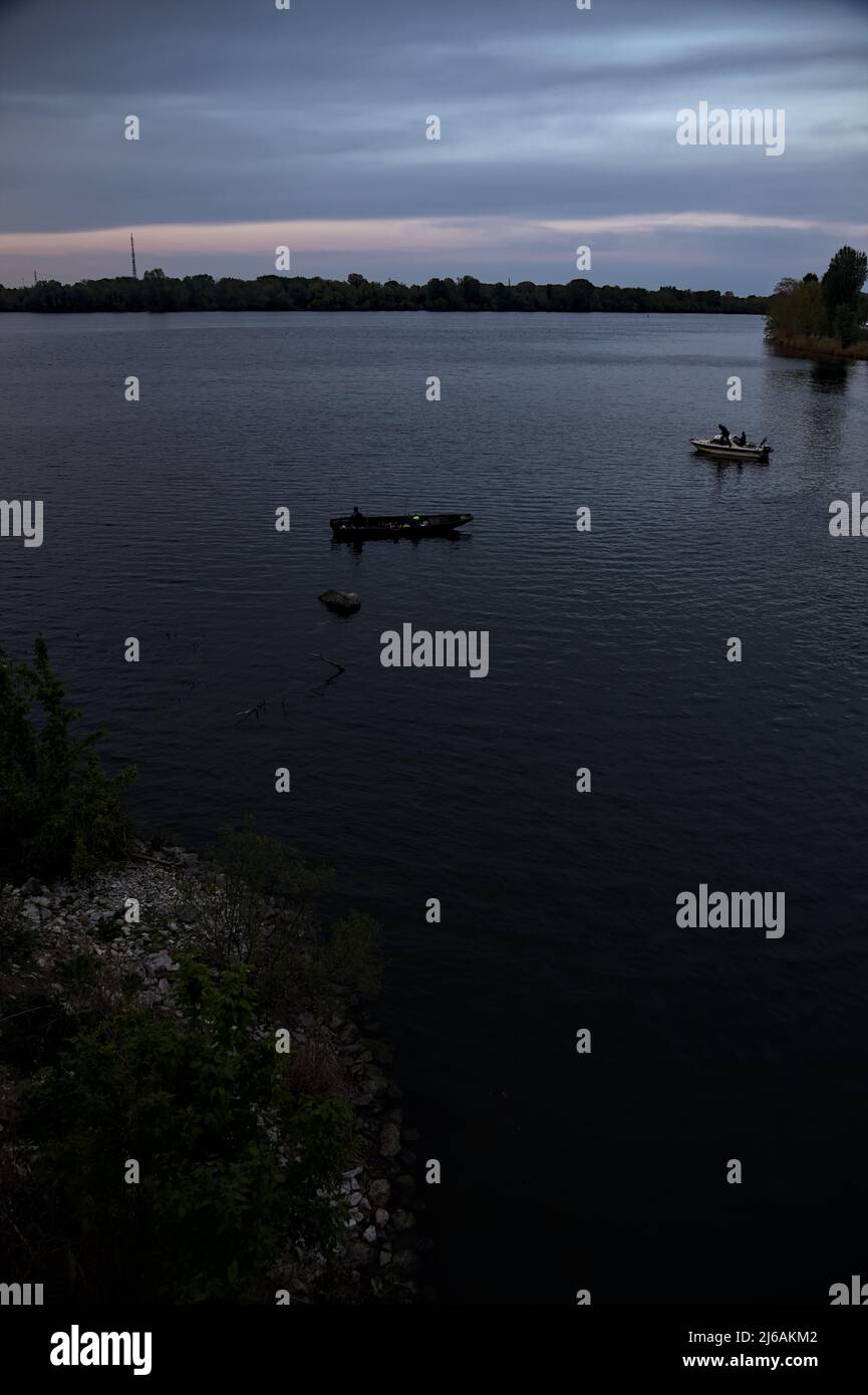 Fishing boats on a lake at dusk Stock Photo - Alamy