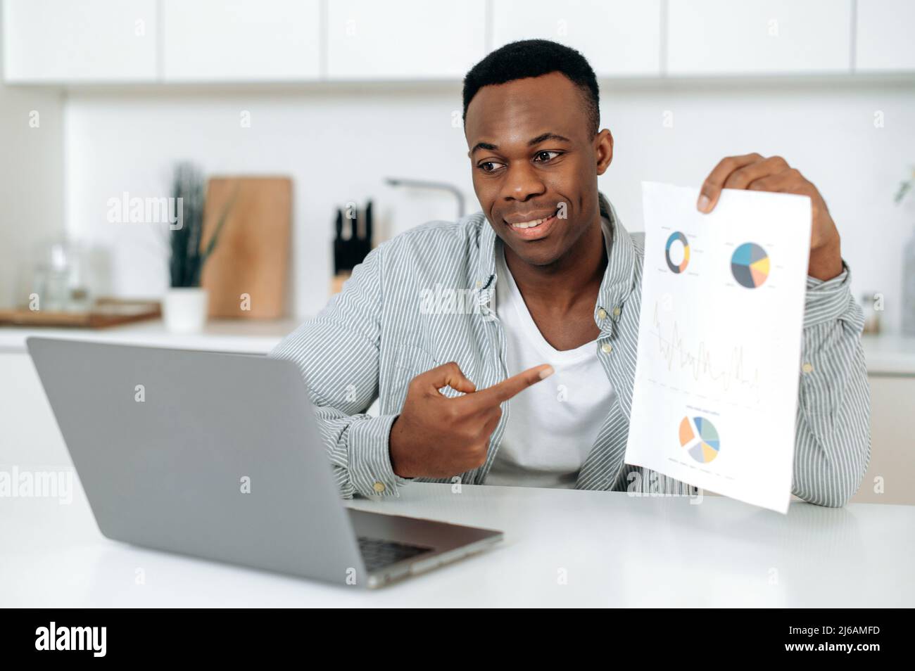 African american successful attractive man, freelancer, mentor or corporate financial advisor, communicates with partners via video call, shows graph, discusses strategy, negotiates,work from home Stock Photo