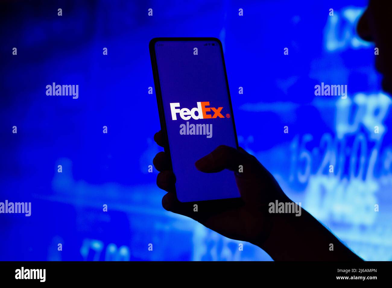 In this photo illustration, a silhouetted woman holds a smartphone with the FedEx Corporation logo displayed on the screen. (Photo by Rafael Henrique / SOPA Images/Sipa USA) Stock Photo