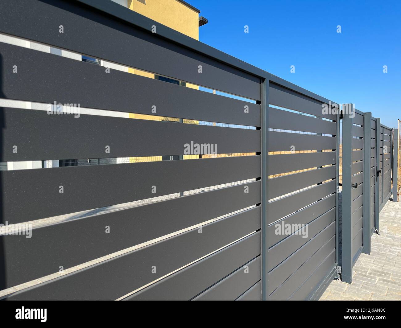 Modern metal fence for fencing the yard area. Horizontal sections of