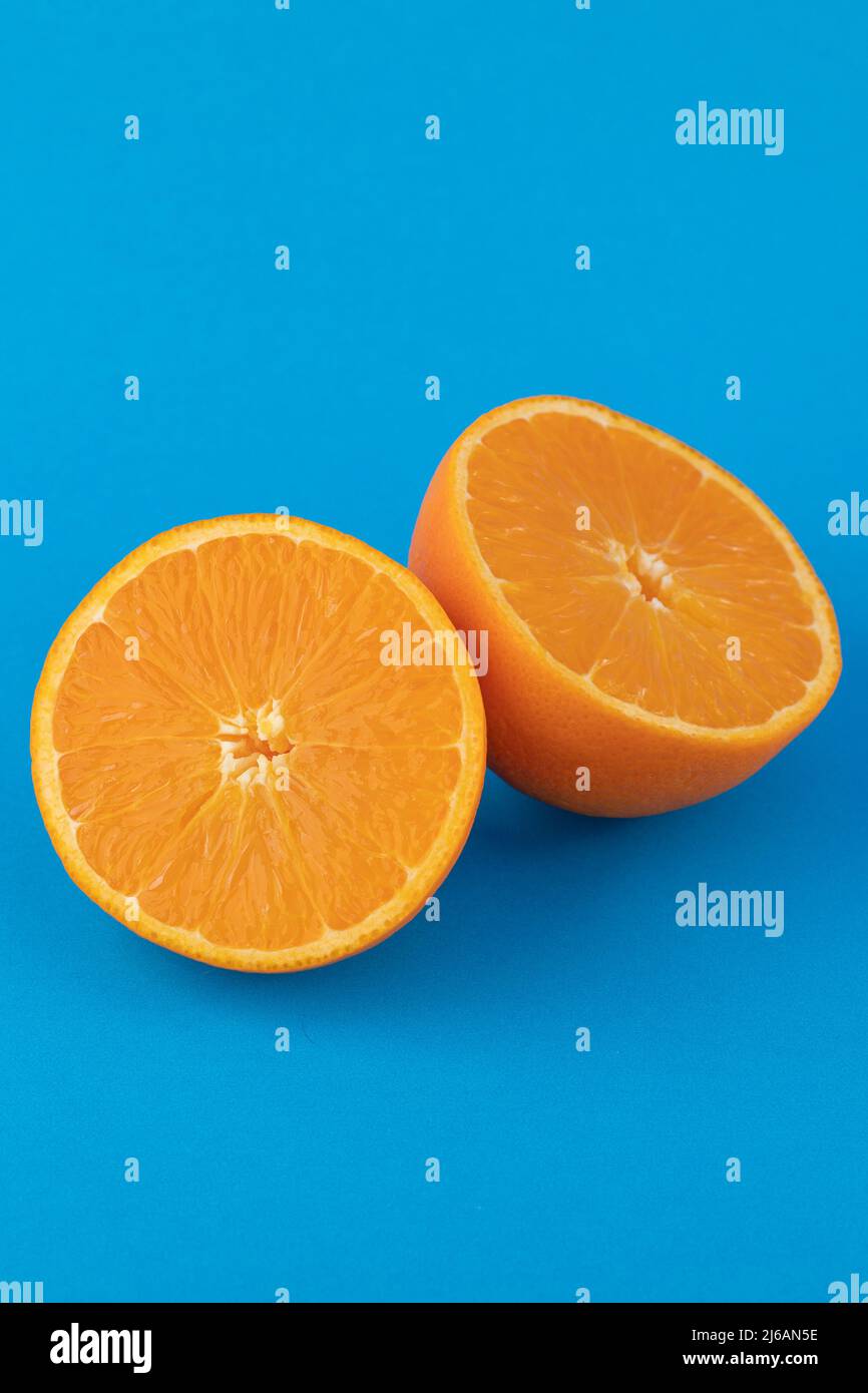 Two navel orange halves on solid blue background Stock Photo Alamy