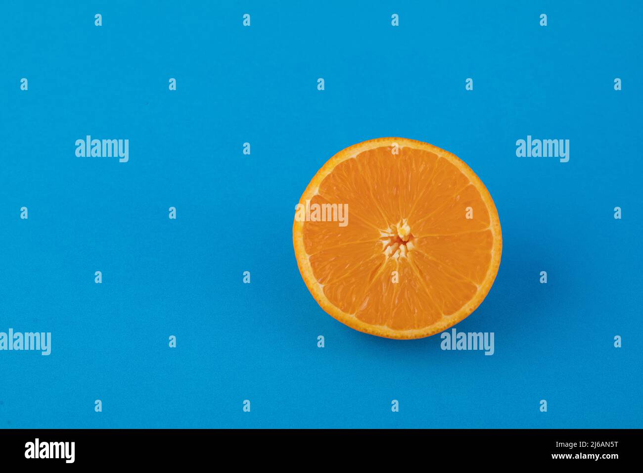 Halved navel orange on solid blue background Stock Photo
