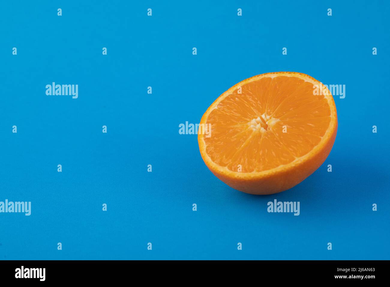 Halved navel orange on solid blue background Stock Photo