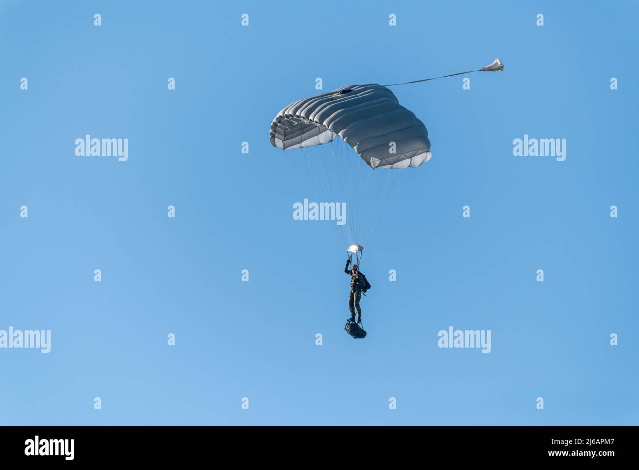 A Belgian Paratrooper performs a sustainment training freefall jump with a load under supervision of jumpmasters assigned to the CE Para training center, on Chièvres Air Base, Belgium, April 20, 2022. (U.S. Army photo by Pierre-Etienne Courtejoie) Stock Photo