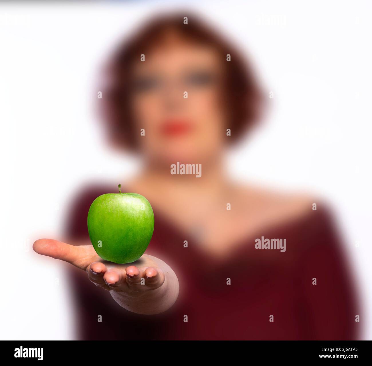 Woman offering a green apple Stock Photo