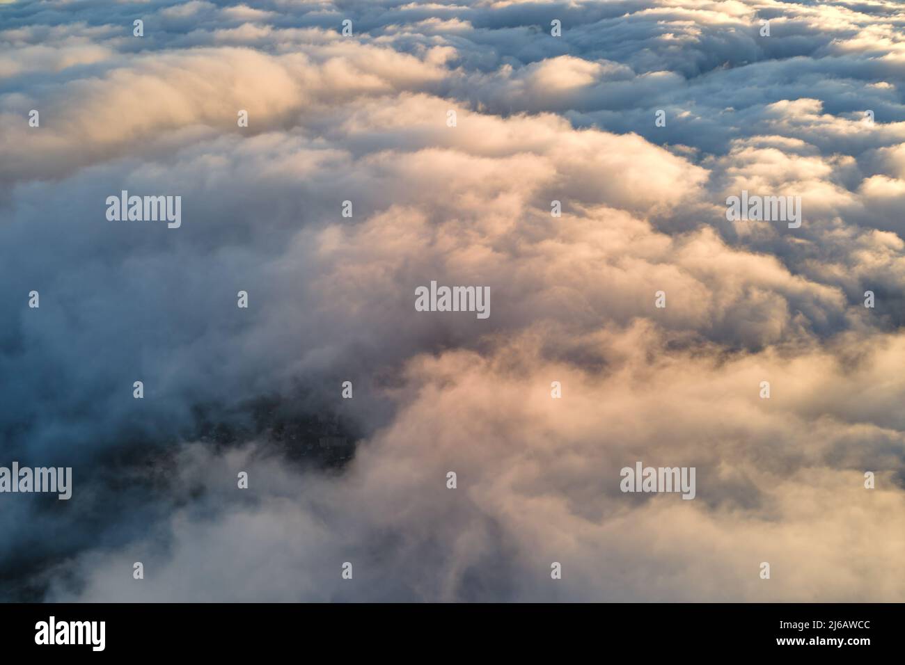 Aerial view from above at high altitude of dense puffy cumulus clouds ...