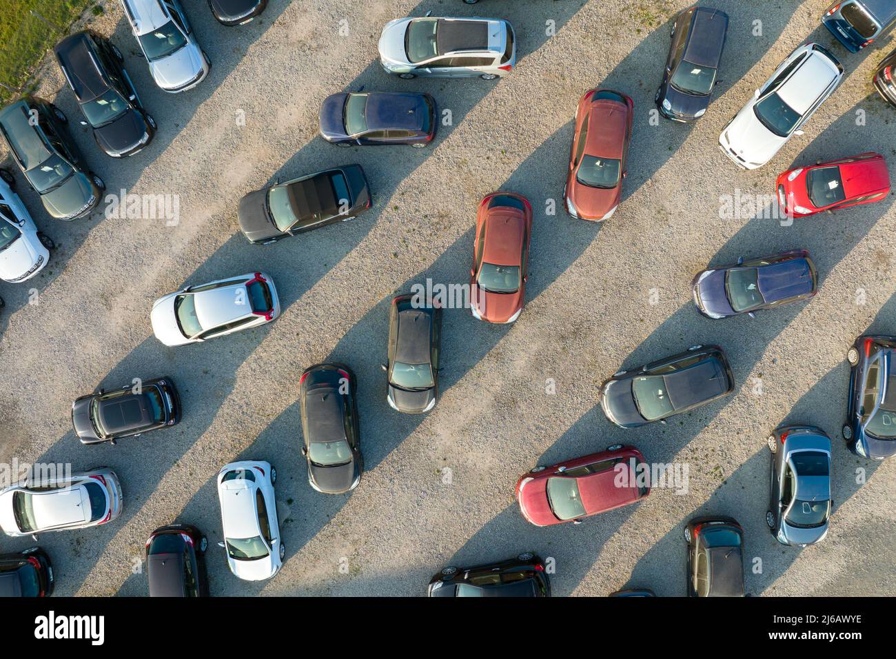 Aerial view of many colorful cars parked on dealer parking lot for sale