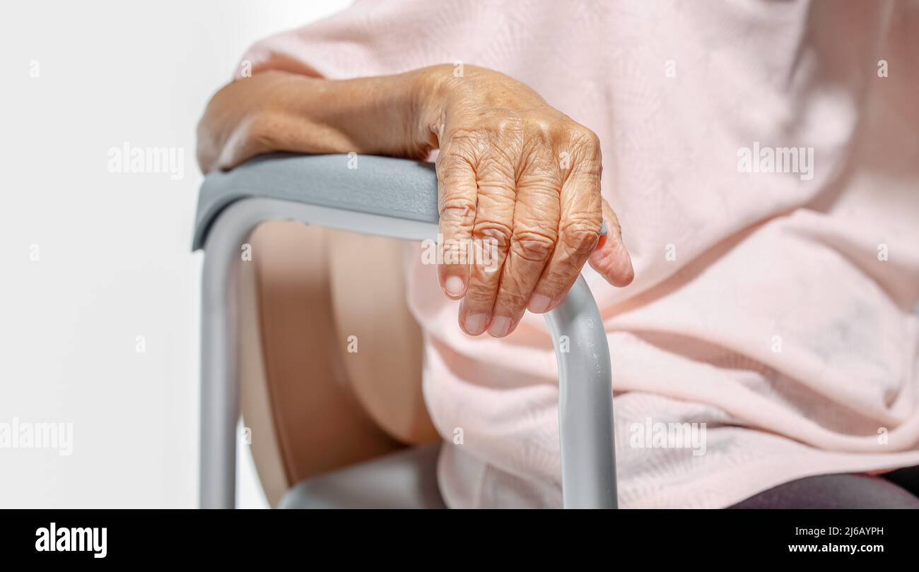 Elderly woman using mobile toilet seat chair Stock Photo