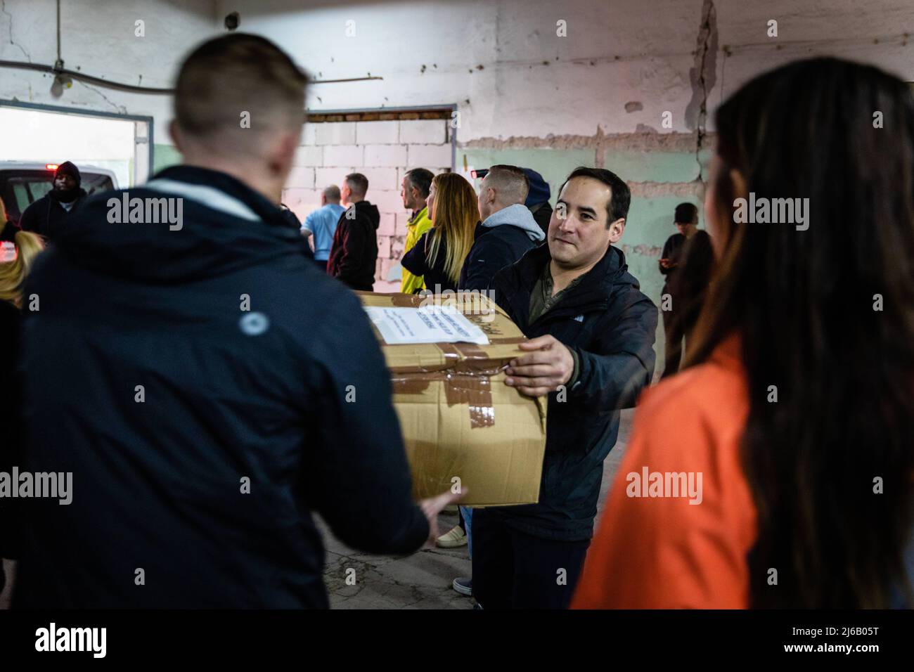 April 6, 2022 - Torun, Poland - Chief Warrant Officer 2 Alex Gernandt, a targeting officer assigned to 1st Battalion, 5th Field Artillery Regiment, 1st Armored Brigade Combat Team, 1st Infantry Division, passes along a box of donations to the sorting area in Torun, Poland, April 6, 2022. The U.S. presence in Europe and its ability to respond during crises quickly reassure allies of their strong partnership. (U.S. Army National Guard photo by Staff Sgt. Gabriel Rivera) (Credit Image: © U.S. Army/ZUMA Press Wire Service/ZUMAPRESS.com) Stock Photo