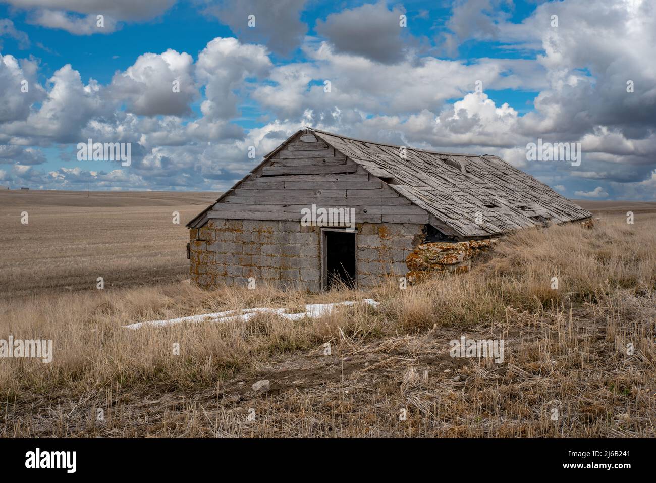 A historic dugout house that was converted into a barn in a field in Saskatchewan Stock Photo