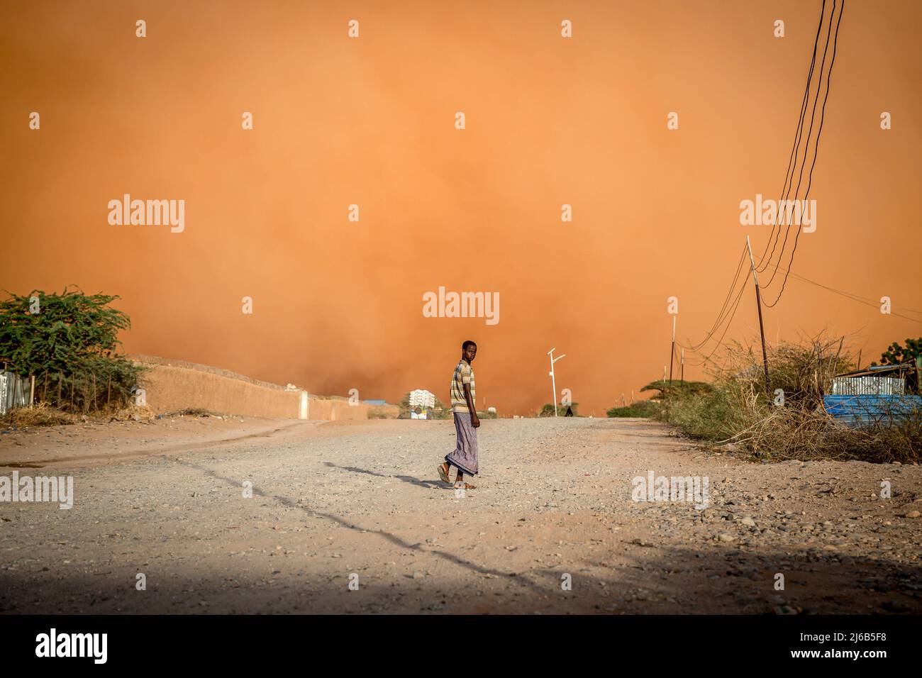 April 14, 2022, Dollow, Jubaland, Somalia: A man walks in front of a sandstorm in Dollow, southwest Somalia. Somalia is one of the most vulnerable countries in the world to climate change and weather is expected to become more extreme. (Credit Image: © Sally Hayden/SOPA Images via ZUMA Press Wire) Stock Photo