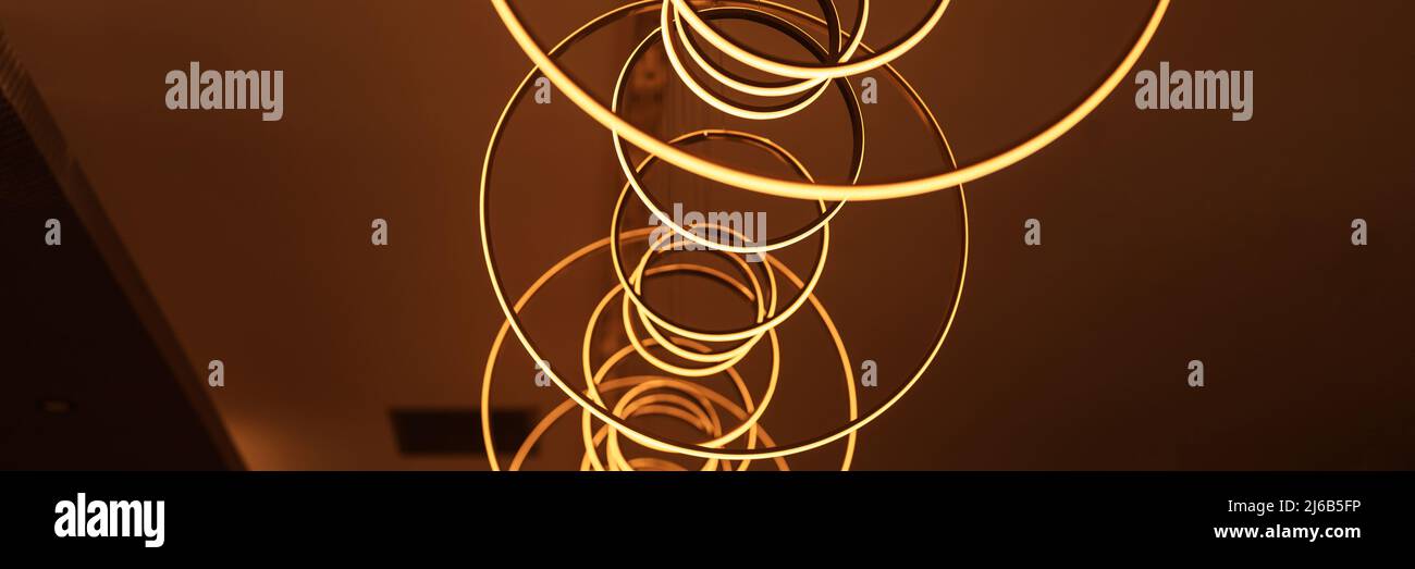blurred hanging lamp bulb in the form of rings. blur beautiful abstract lighting under the ceiling from modern pendant electricity round lamps chandel Stock Photo